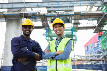 Structural engineers and construction workers are holding blueprints inspecting structure. sky train track construction in city. Blue collar wears a safety hardhat while working on construction site.
