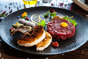 Beef tartare from Black Angus. Onion, quail egg, tomato sauce, mustard mayonnaise. Delicious healthy Italian traditional food closeup served for lunch in modern gourmet cuisine restaurant