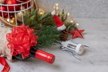 Christmas Red wine and wine opener with santa hat decoration on table background.