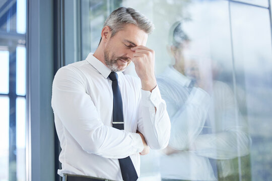 Window, Business Man And Stress With Headache, Burnout And Overworked In Office. Senior Male, Entrepreneur And Ceo Frustrated, Mental Health And Leader With Depression, Pain And Tired In Workplace.