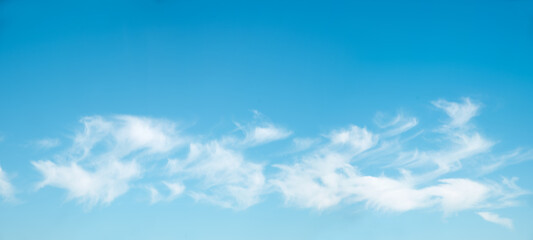blue sky background with fluffy cirrus clouds in the lower half