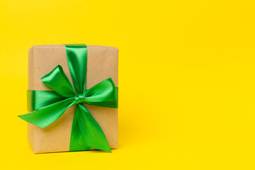 Gift box with green ribbon bow on color background