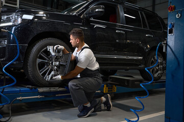 Worker put device for technical testing on car wheel