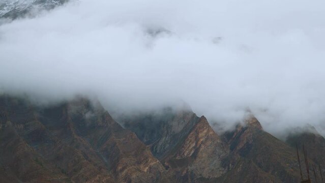 4K shot of fog around the mountain peaks during the stormy weather at Tandi in Lahaul Spiti district at Himachal Pradesh, India. Clouds rolling over the peaks of the mountain. Nature background.	