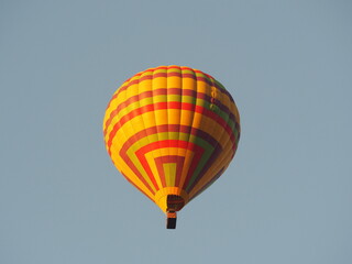 Naklejka premium Hot air balloon over blue sky background. Yellow balloon against the sky in Laos, Vang Vieng 