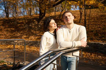 Happy couple with a dog stand on the park stairs