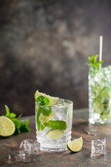 Mojito cocktail with lime and mint in glass on a grey background