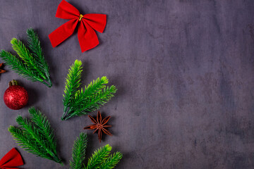 Christmas flat lay with spruce twigs and decorations on dark gray table. Festive composition. Copy space