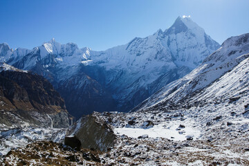 Annapurna base camp with Mt. Machapuchare on the horizon. Snowy winter landscape in Himalaya mountains, Nepal.