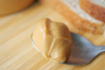 close up of peanuts butter on spoon on table 