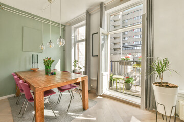 Dining table in cozy living room near glass door leading to balcony