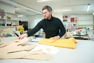 Designer works with fabrics and patterns at the cutting table