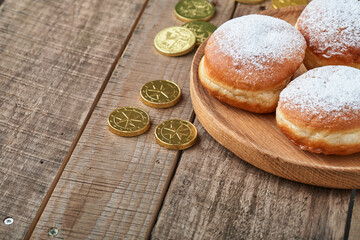 Happy Hanukkah. Hanukkah sweet doughnuts, gift boxes, white candles and chocolate coins on old  wooden background. Image and concept of jewish holiday Hanukkah. Top view.