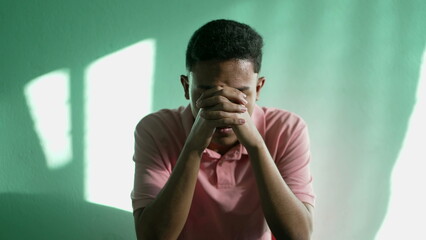 Faithful young hispanic man praying to God hands folded in worship. Hopeful South American person Hand clasped together in prayer. Hope and Faith concept