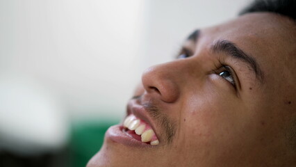 Brazilian man closeup face looking at sky smiling. happy faithful emotion