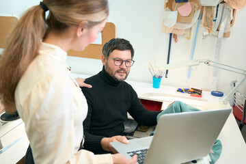 Obraz premium Woman manager with laptop put her hand on shoulder man designer