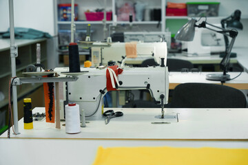 Modern sewing machines on the tables in the workshop