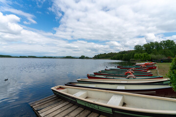 Obraz premium Lake landscape with little colorful boat and a little wharf. Landscape with clouds