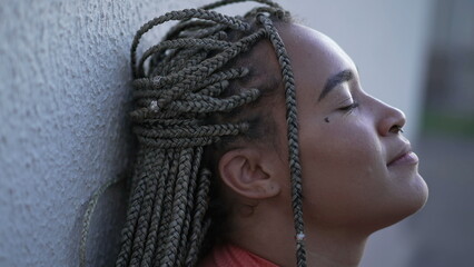 One meditative black woman closing eyes in contemplation. Female person in meditation. Profile face closeup