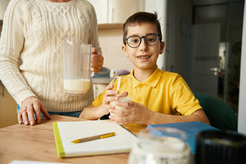 Portrait of boy holding cup of milk, looking at camera