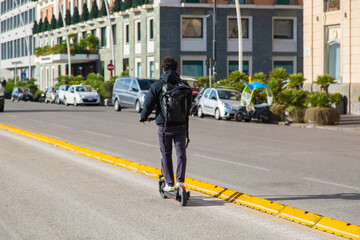 A young guy rides an electric scooter on a special road in Europe