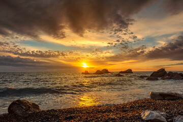 Fototapeta na wymiar Sunset sky over sea and rocks