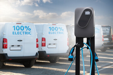 Electric vehicles charging station on a background of a row of vans. Green transportation concept	