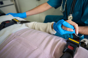 Woman grabs hand of doctor while being transported by ambulance