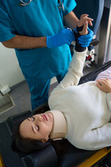 Obraz premium Woman is sitting on medical procedure for attaching fixing bandage