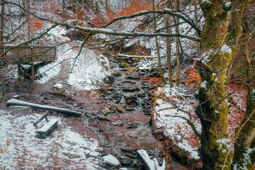 Bach in der Klamm im Helletal bei Winterberg und Bank im Schnee