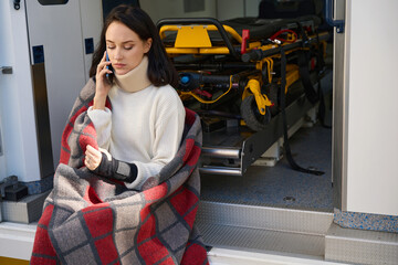 Woman with neck and wrist brace talking on the phone