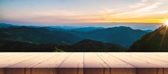 Wooden table top with sunset mountain landscape, for display product.