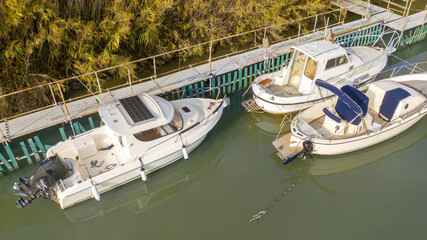 Aerial view of three boats on the river. The boats are empty and anchored at the dock.