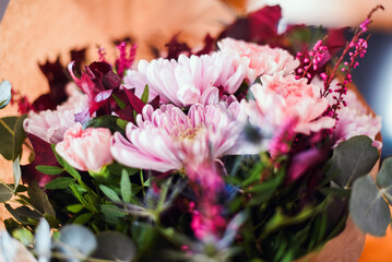 Detalle de las flores de un ramo en tonos rosas y granates. Eucalipto plateado, crisantemo, clavel,...