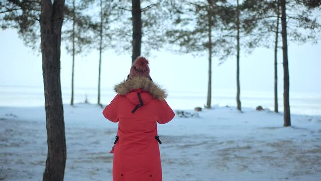 Woman In Winter Red Parka Strolling In Forest 