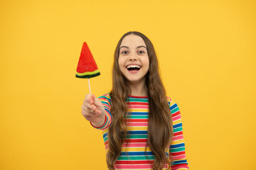 Cool teen child with lollipop over yellow isolated background. Sweet childhood life. Teen girl with yummy lollipop candy.