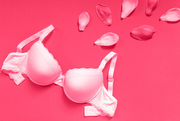White new bra on a magenta background. Bra, lace lingerie on a viva magenta background. Beauty blog concept. Top view, flat lay. color of the 2023 year	
