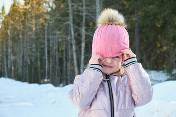 cute girl on a sunny winter day against the backdrop of snow and forest