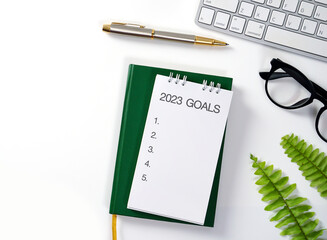 2023 New Year Goal Target, Action, Plan, Idea, Inspiration Concept. Business concept of top view 2023 goals list with notebook, Notebook, keyboard, glasses with pen on table.  