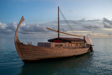 Eine traditionelle Dhoni nach einer Sunset-Cruise auf den Malediven bei Sonnenuntergang im...
