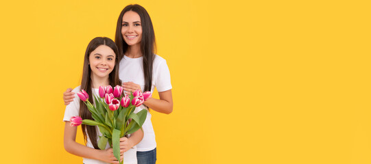 Mother and daughter child banner, copy space, isolated background. happy mother and daughter with fresh tulip flowers on yellow background.