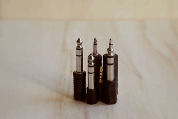Set of audio jack adapter 6,3 mm and 3,5 mm on a wooden bench. Close up. Audio technology concept.