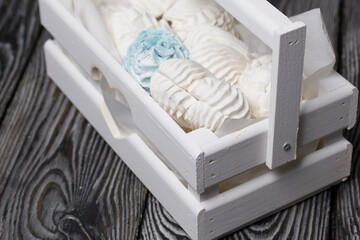 Marshmallow cones. Homemade zephyr. Packed in a wooden decorative box. On the background of the boards. Close-up.