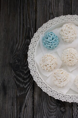 Marshmallow cones. Homemade zephyr. Arranged on a platter. On the background of the boards. Taken from above.