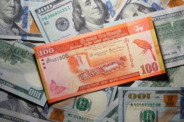 Fototapeta na wymiar 100 Sri Lankan rupees on a background of 100 dollar bills