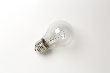 flat lay of single light bulb on white surface