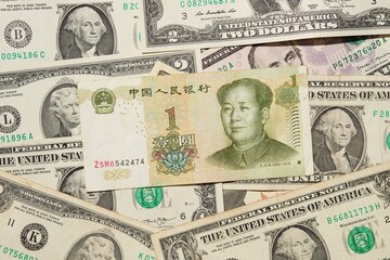One Chinese yuan bank note on USA dollars background