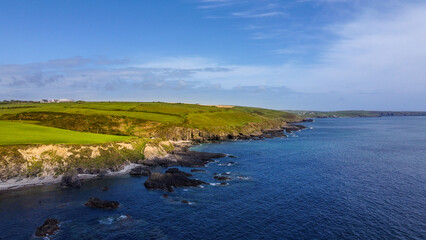 Green hills on the Atlantic Ocean on a sunny spring day. Blue sky over the sea coast. The coastline of Ireland, West Cork.