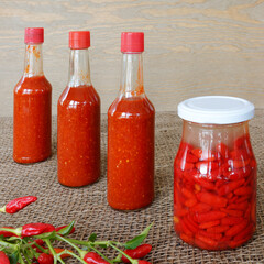 Hot sauce made from fermented fresh Tabasco chili peppers. Jar with fermentation process and ready...