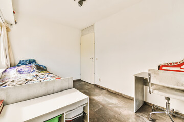 a room with a bed, desk and other items on the floor in front of the door that leads to another room